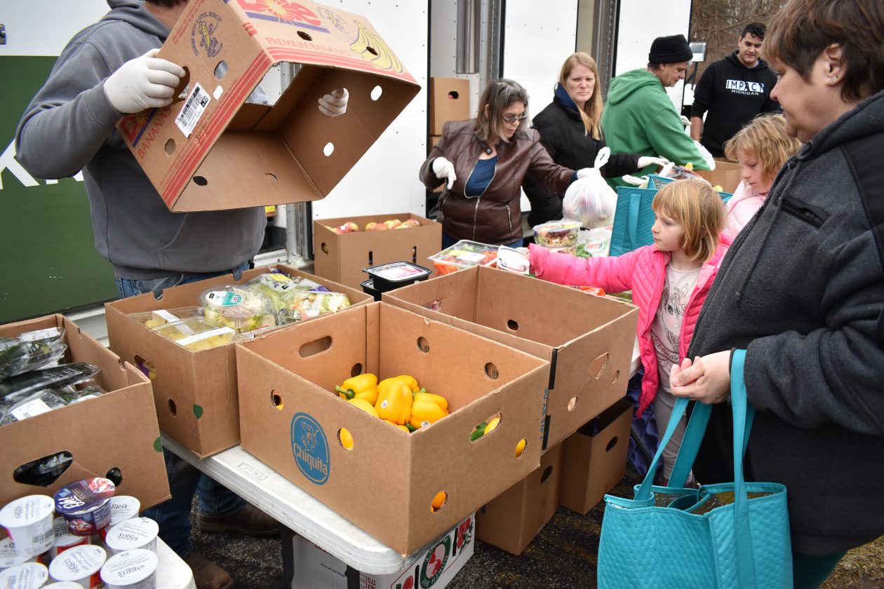 A girl reaches for food at a Mobile Food Pantry.