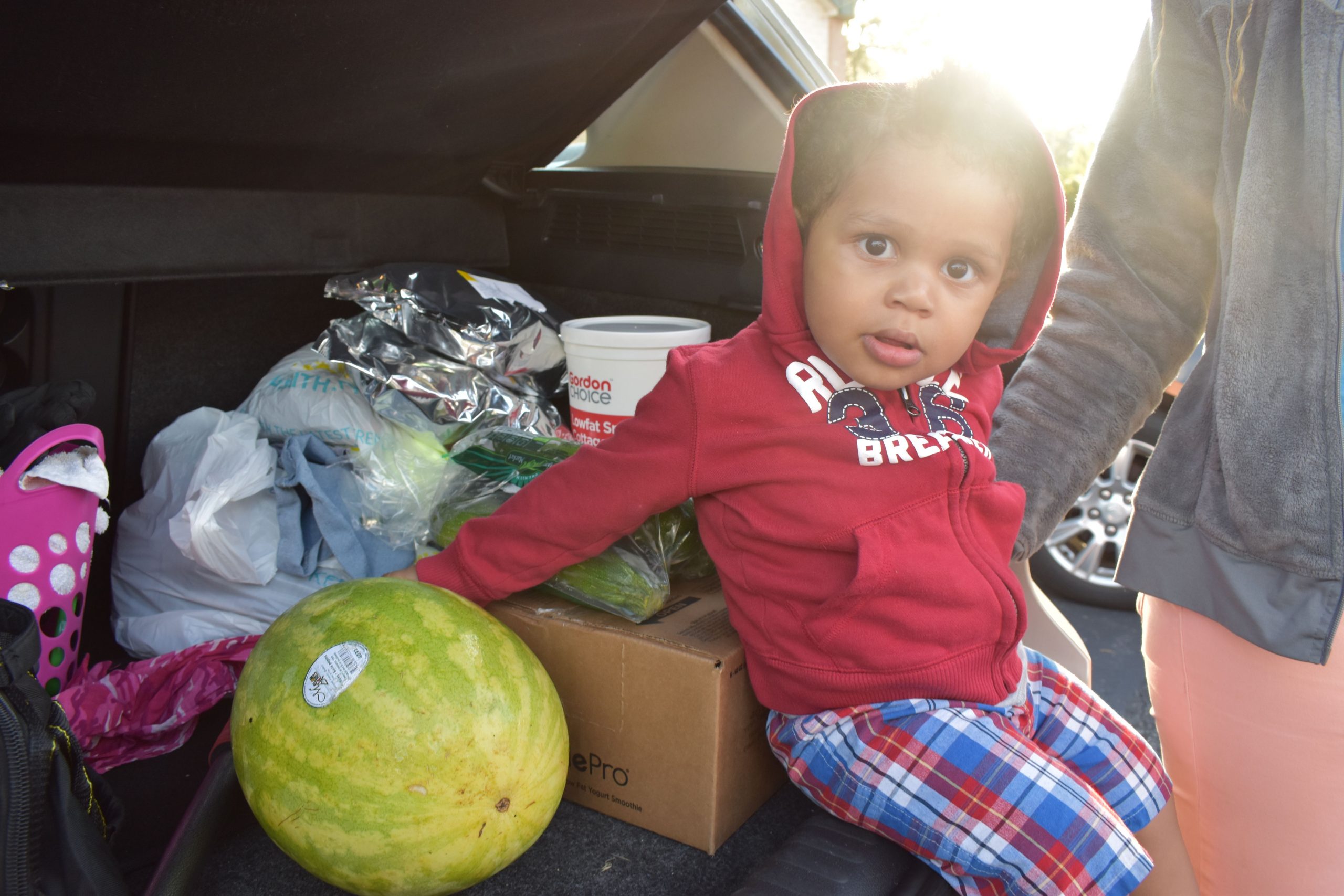 little boy sitting in car with with food