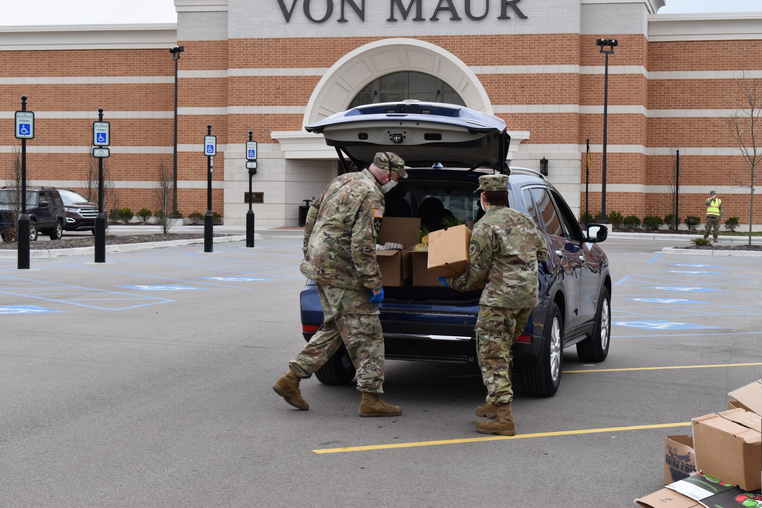 Kim and fellow National Guard member filling a trunk with food