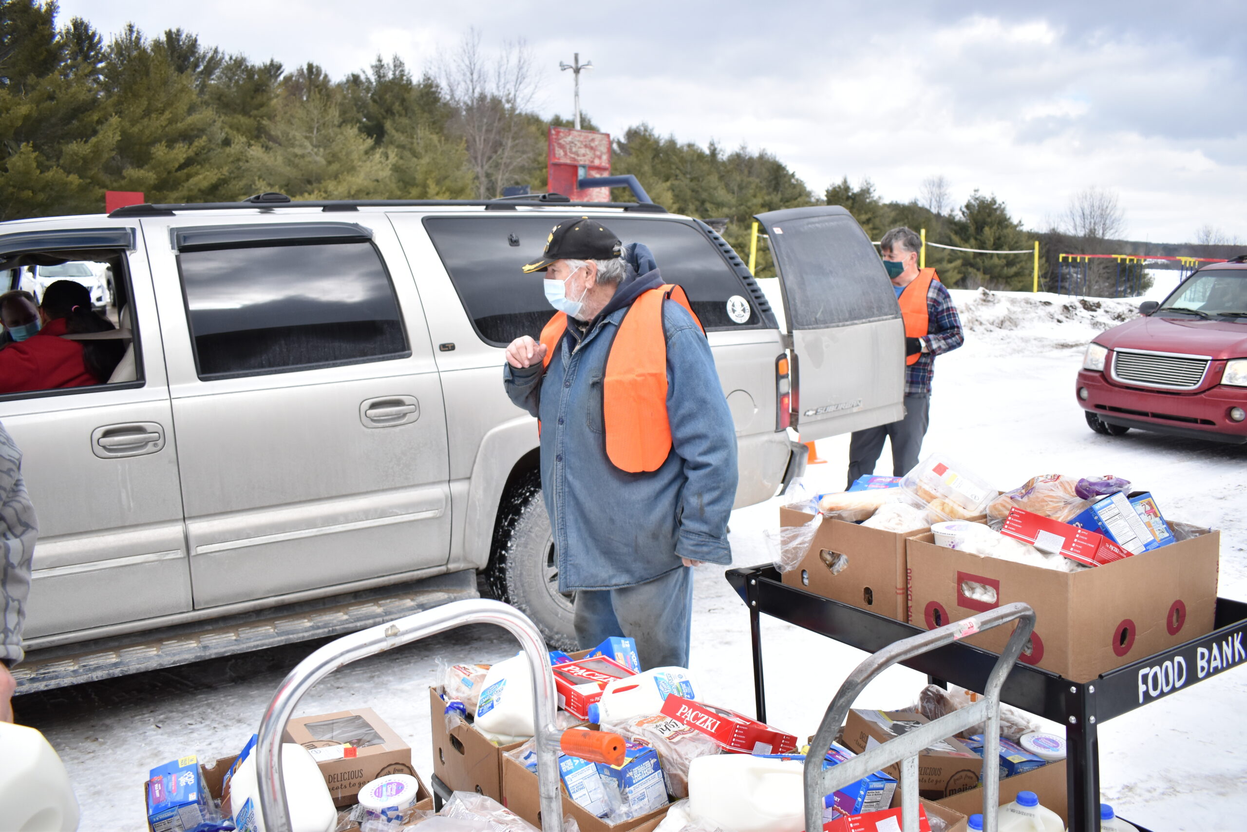 A volunteer loads a truck with food