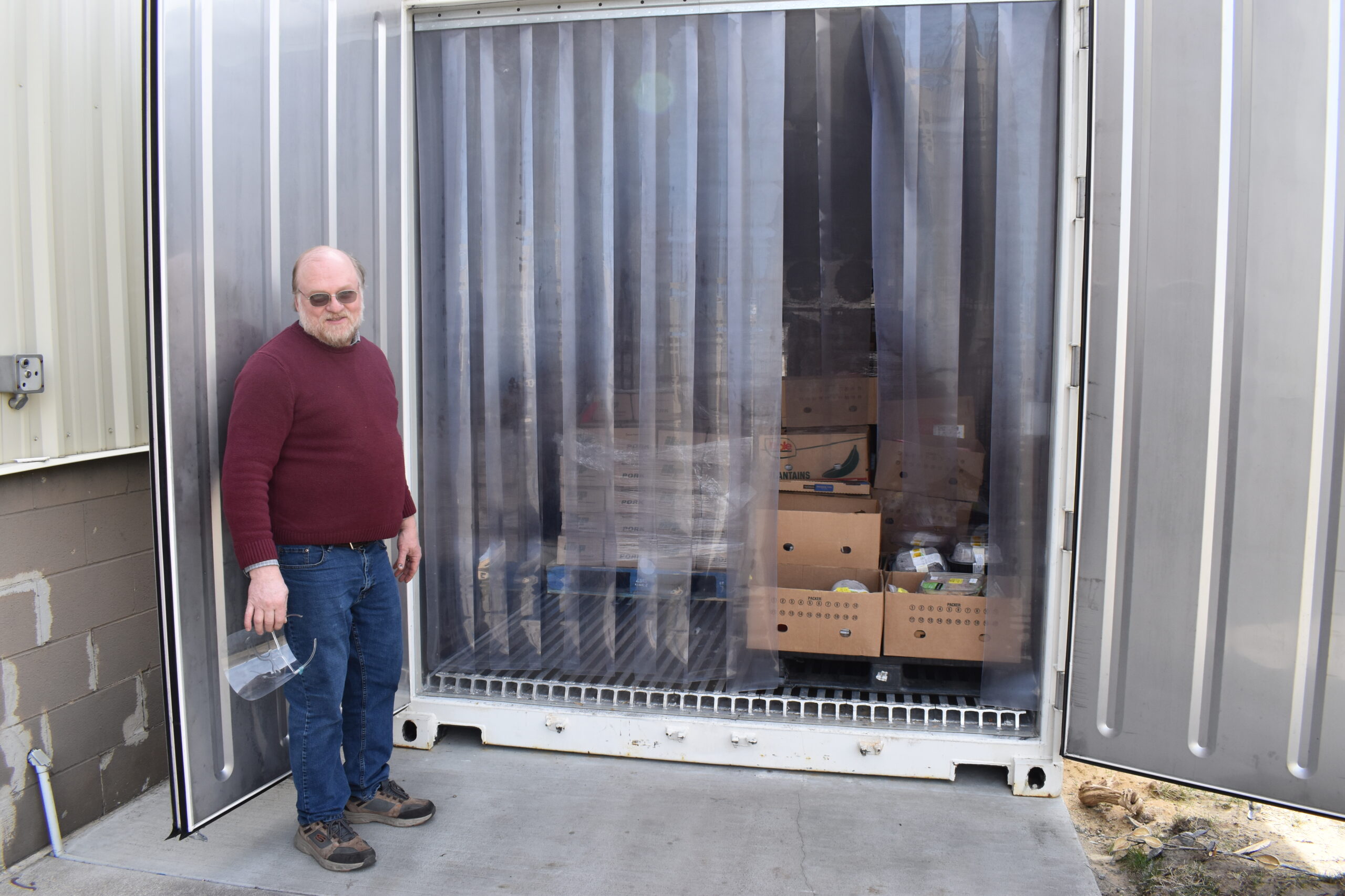 Rich poses in front of his new freezer, a large shipping container.