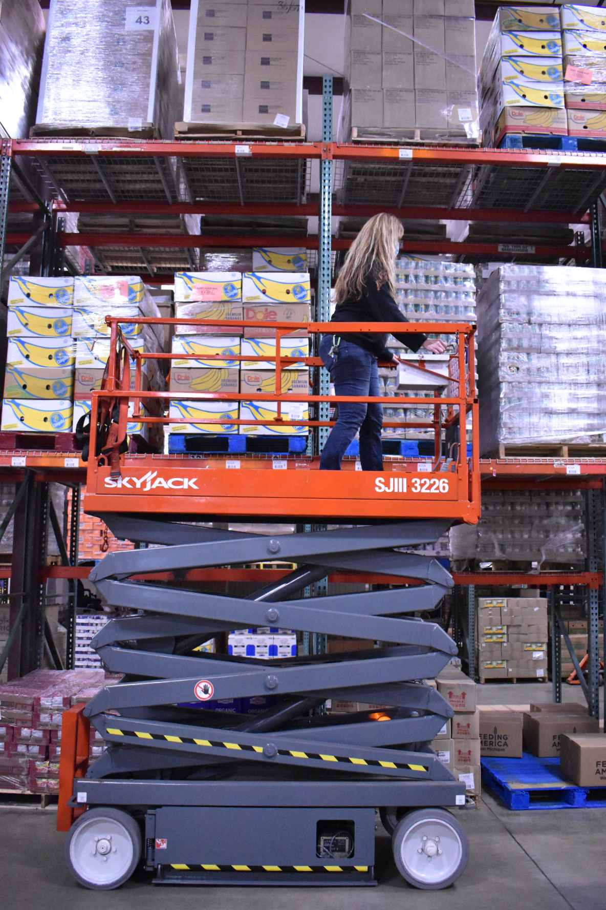 Leslie demonstrates the scissor lift, which has a caged platform to stand on and an accordion to push it up high.