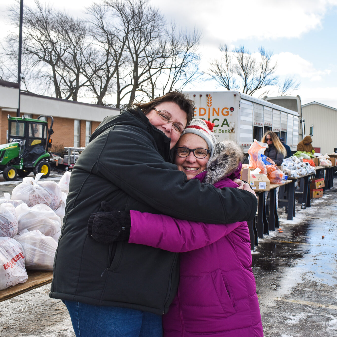 volunteer and client hug at a mobile pantry