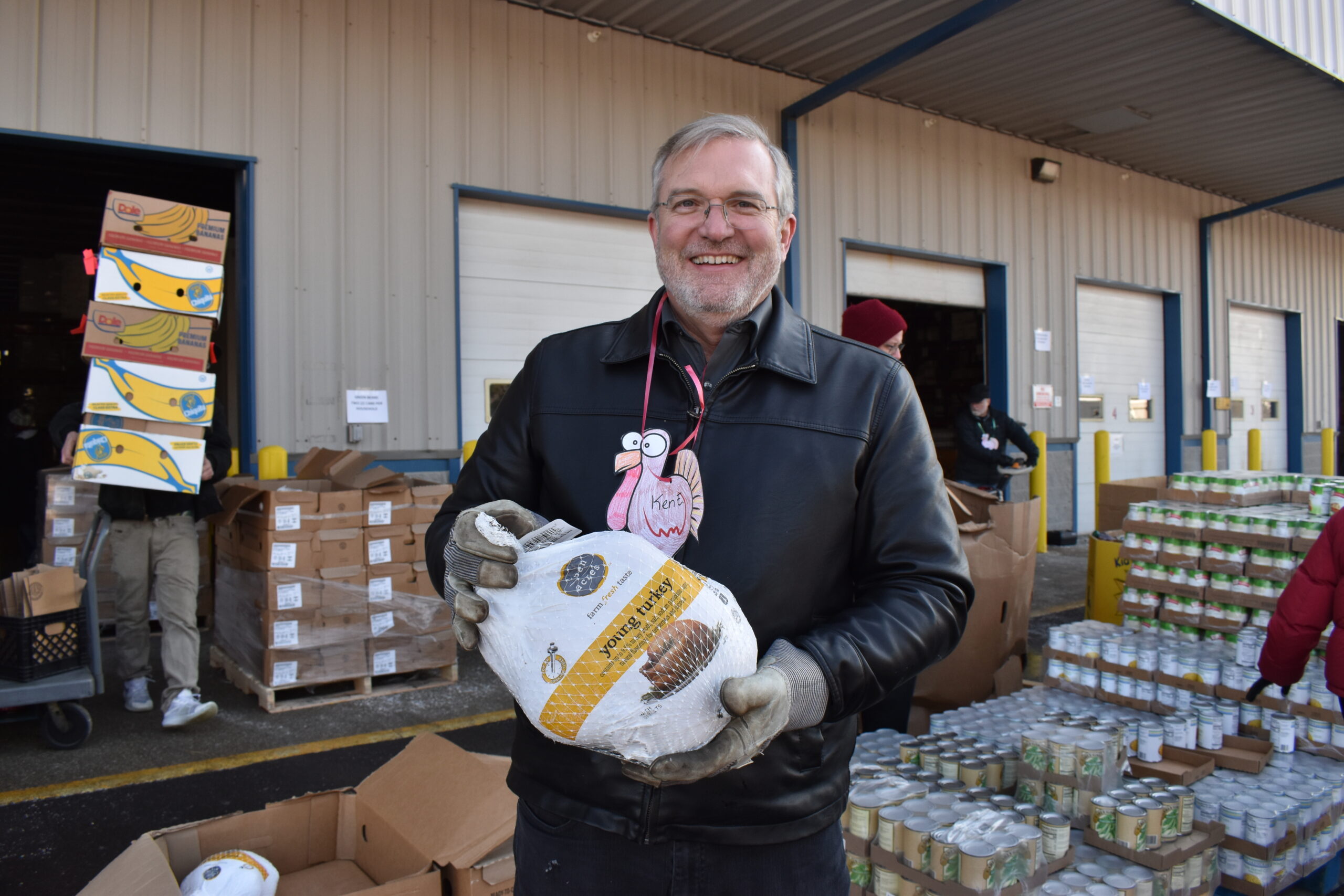 Ken Estelle smiles while holding a turkey