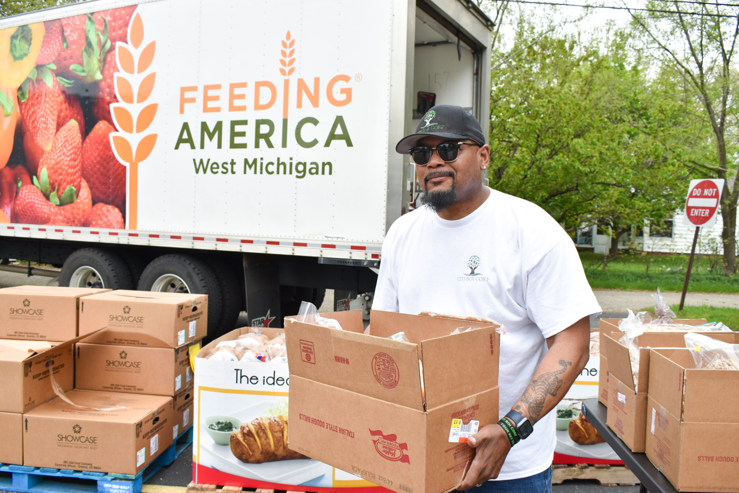 Rob holding a box of food by the Mobile Pantry truck