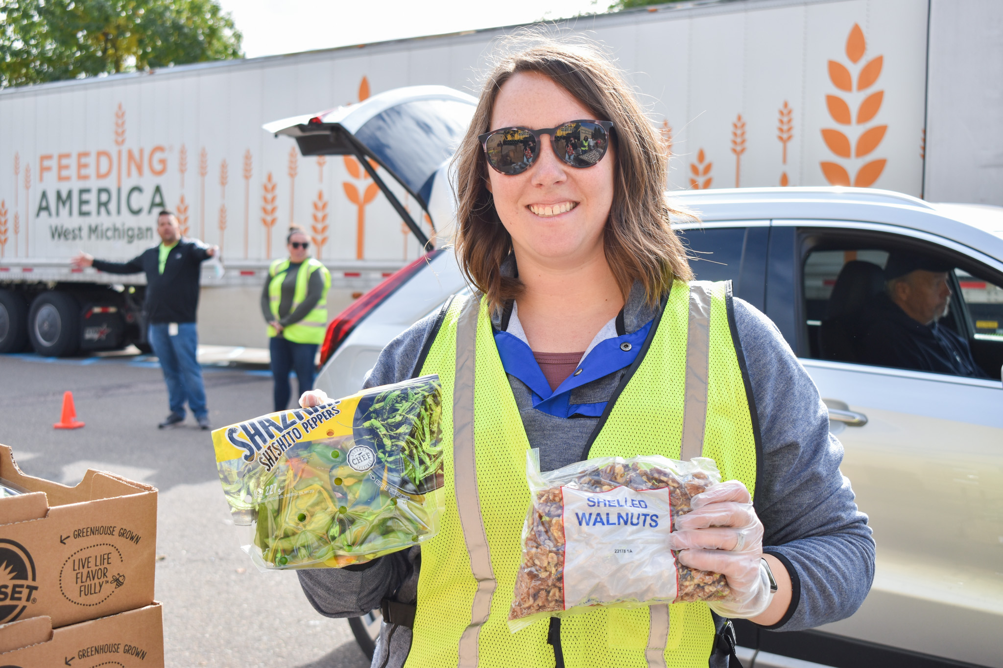 Volunteer holding up walnuts and peppers