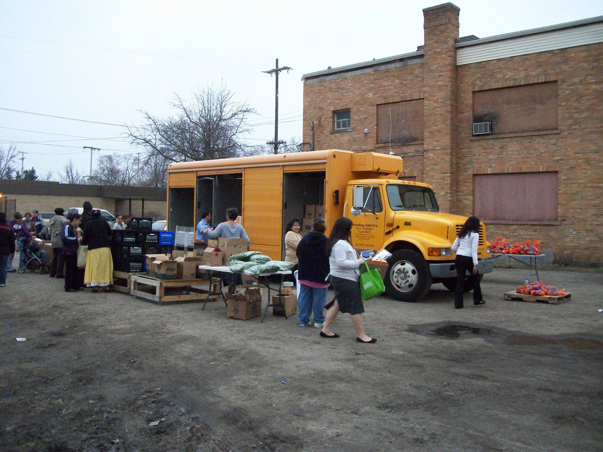 A Mobile Food Pantry in a yellow truck, nicknamed "The Bus", at Missionary Church of Christ in Grand Rapids.